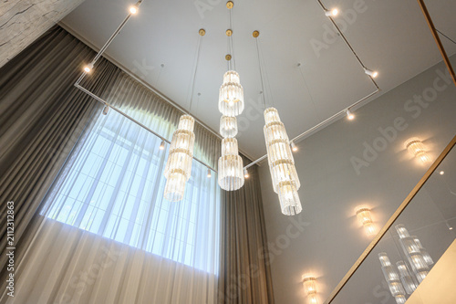 Obraz na plátně sophisticated interior spotlights tiered crystal chandeliers suspended from clean white ceiling