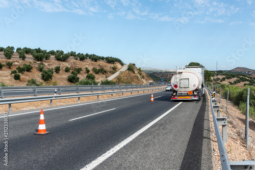 Obraz na plátně Fuel tanker truck stopped on the highway with emergency traffic cones