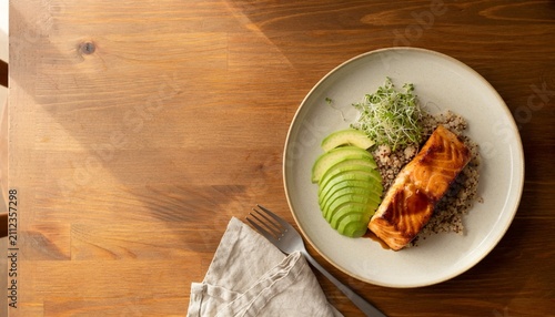 Salmon fillet served on a plate with quinoa and sliced green apples at a table