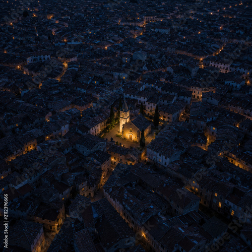 Christianity Seen From Above – Glowing Historic Church Among Darkened City Rooftops at Blue Hour, Symbolic Aerial View of Hope and Guidance
