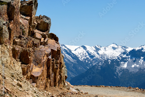 colorful cliff along mountain trail with snow capped mountains at Whistler British Columbia