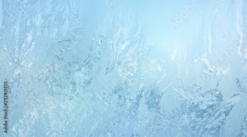 Frosted glass texture with blue glow. Abstract icy window pattern for winter background.
