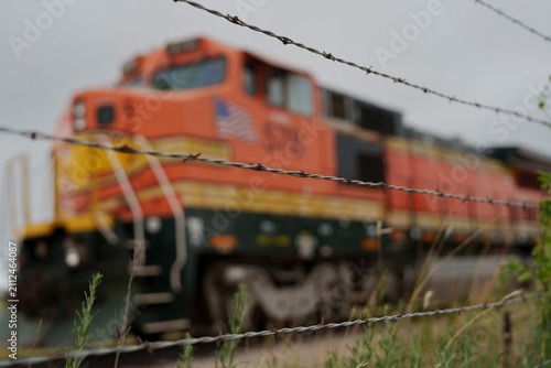Barbed wire preventing access to retired freight locomotive awaiting further use or dismantling on an industrial site in North Texas USA,