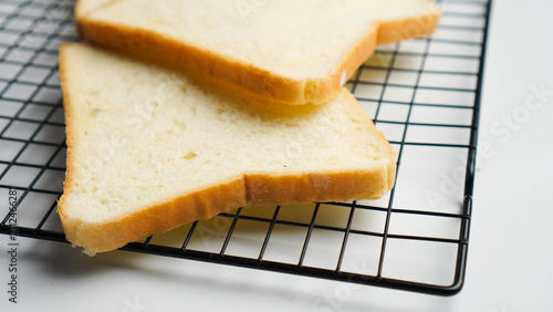 A close up of a metal rack with four slices of bread on it