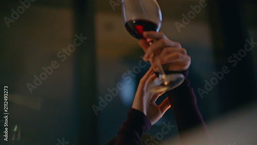 Foto Happy woman raising red wine glass in evening apartment, close up lady relaxing