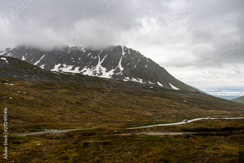 Foto Mountain road winding through alpine tundra under cloudy skies in Hatcher Pass n