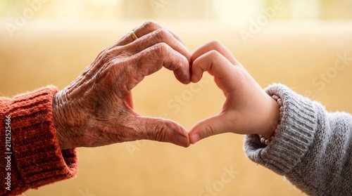 Close-up of elderly and child hands forming heart shape, symbol of love, family connection, inter generational care, compassion, trust, support, kindness, and lifelong bonding