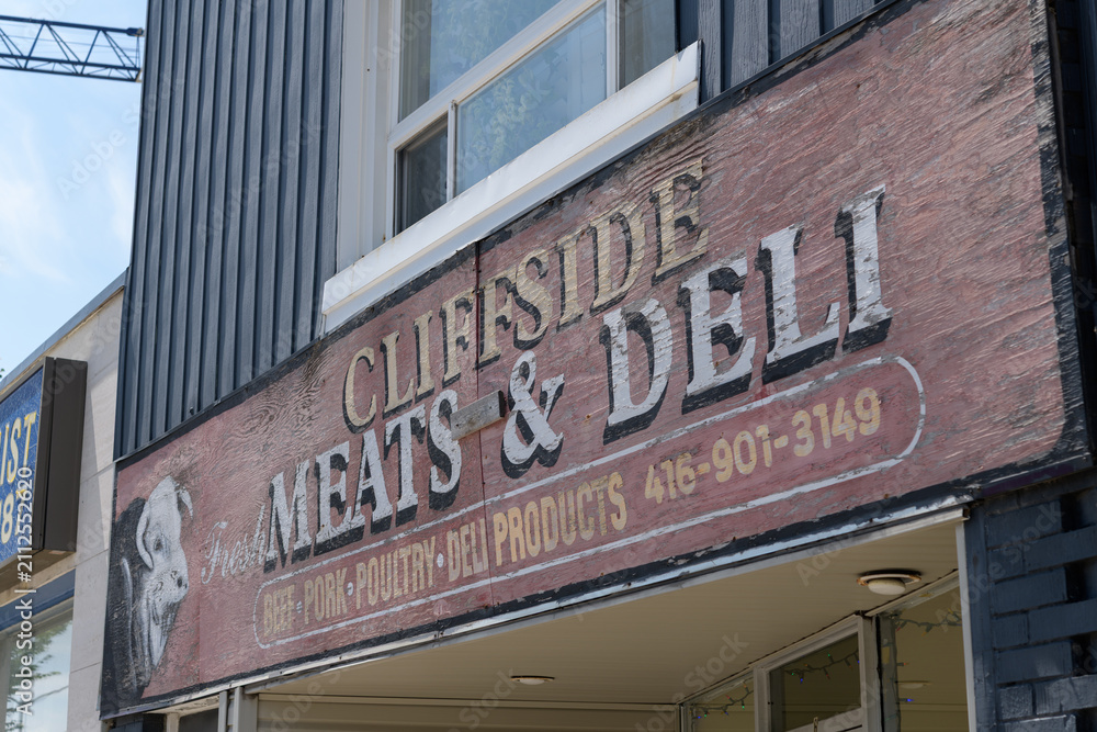 Fototapeta premium old painted sign on the exterior of Cliffside Meat & Deli, a butcher shop and deli, located at 2476 Kingston Rd, Scarborough, Toronto