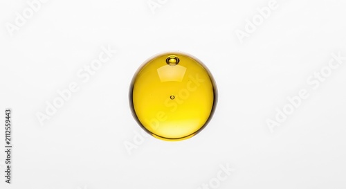 A pristine macro view of a golden meadowfoam seed oil droplet isolated on a seamless white backdrop, showing pure texture and clarity, shiny, skincare, bubble