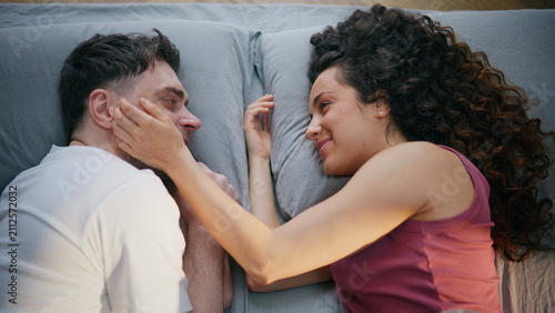 Bild auf Leinwand Happy couple caressing faces top view bed