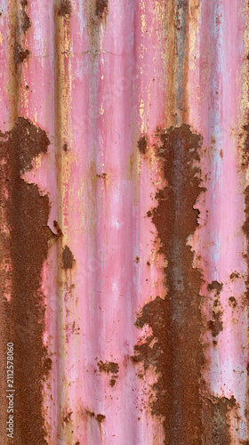 Rusty pink corrugated metal wall with peeling paint texture