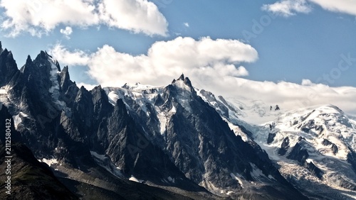 Bild auf Leinwand Les Drus et cimes enneigées du massif du Mont-Blanc sous les nuages