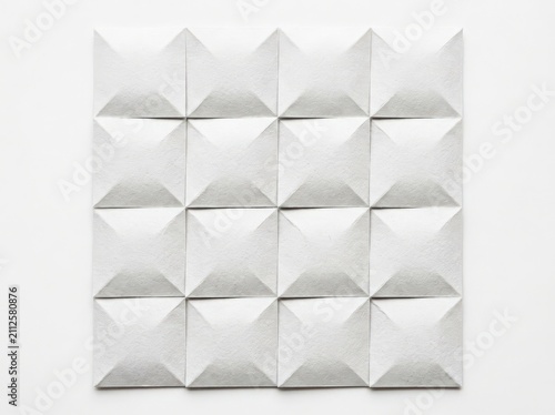 White textured paper background with geometric folded pyramid pattern and soft shadows for minimalist