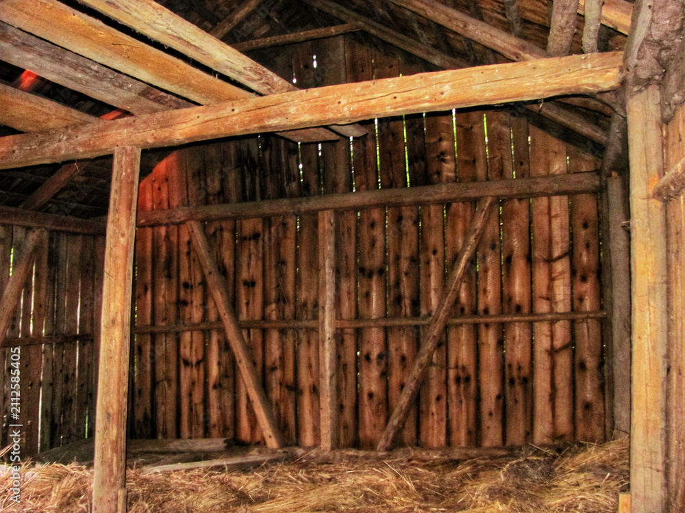 Naklejka premium Interior of an empty old wooden barn prepared for storing hay in a village