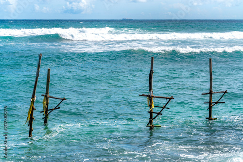 Wooden stilt fishing poles in the sea at Ahangama Beach, Sri Lanka. Traditional wooden stilt fishing poles standing in the ocean at Ahangama Beach, Southern Province, Sri Lanka. 