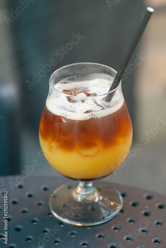 Foto iced coffee with orange juice in a glass, cold refreshing summer drink with blur