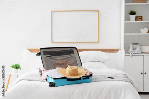 Open blue suitcase with clo...