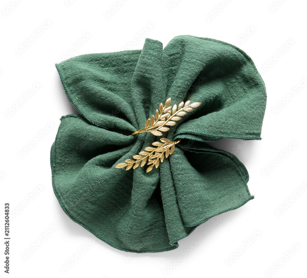 Naklejka premium Folded green linen napkin with golden olive branch napkin ring, elegant table setting and dinnerware accessory, isolated on a white background