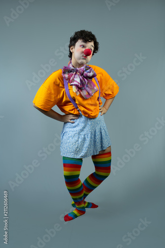 Full length portrait of young lady dressed as a clown. Studio shot with copy space, ideal for circus art, children's party, funny character, and entertainment.