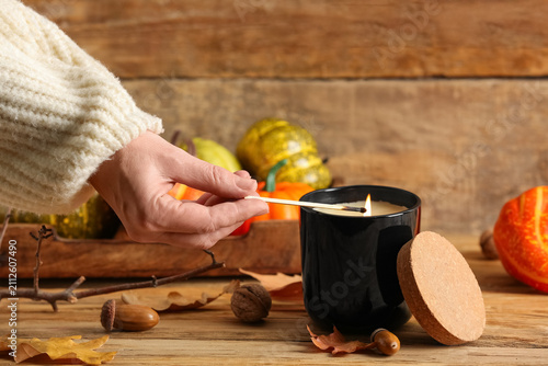 Female hand lighting candle...