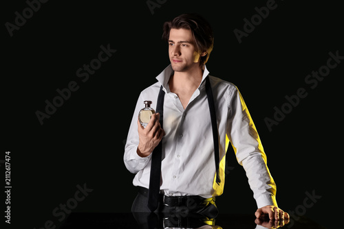 Handsome man with bottle of...