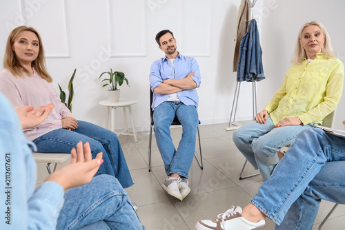 People sitting in chairs at group therapy session