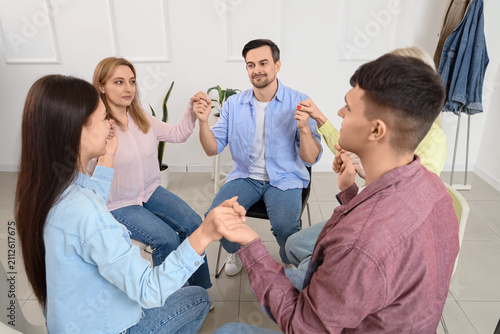 People holding hands at group therapy session