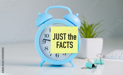 Foto Blue alarm clock with yellow sticky note