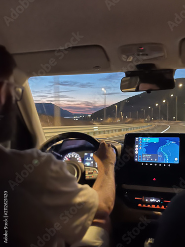 Foto Man driving car on coastal highway navigating with GPS in evening, exploring sce