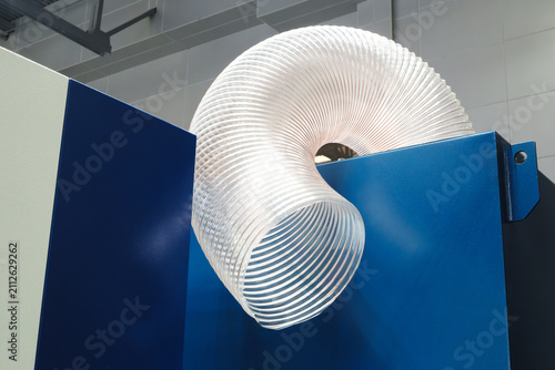 Foto Clear plastic corrugated ventilation pipe is attached to an industrial machine to supply air to machine