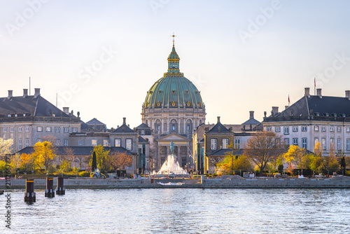 Fotografía Frederiks Kirke, a notable structure in Copenhagen, is seen surrounded by water and autumn trees