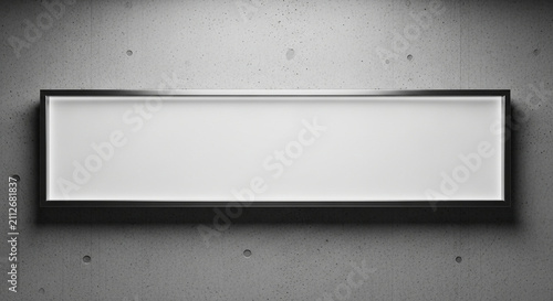 A long, horizontal, glowing panel with a sleek dark frame is affixed to a textured, grey wall, presenting a bright, blank space perfect for displaying information, text, or branding elements