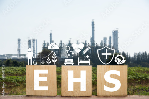 EHS text on woods and icons on blur the image of the industrial factory background.