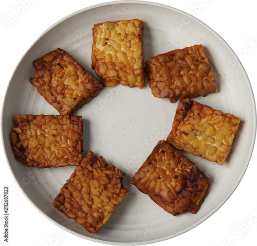 фотографія golden brown tempeh slices served on plate