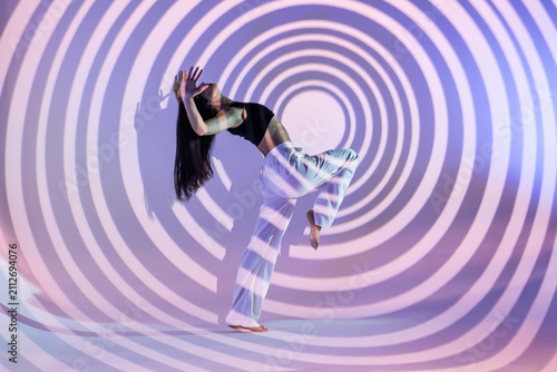 Latin woman urban dancer in hypnotic spiral light projection