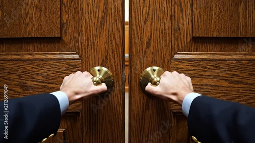 Hands Grasping Ornate Brass Doorknobs on Professional Wooden Doors Symbolizing Opportunity and Transition in Business