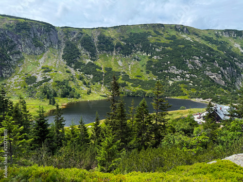 Scenic Mały Staw Mountain Lake in the Karkonosze Mountains with Crystal Water, Green Slopes and Dramatic Summer Sky