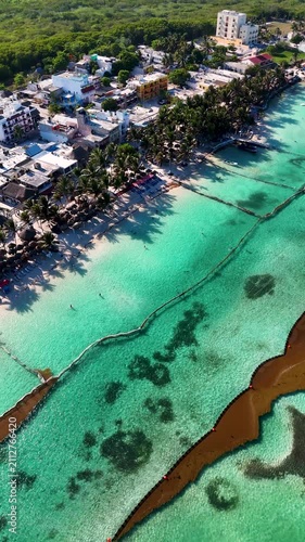 Vertical aerial drone shot close to Mahahual beach resort with clear shallow waters in Quintana Roo, Mexico