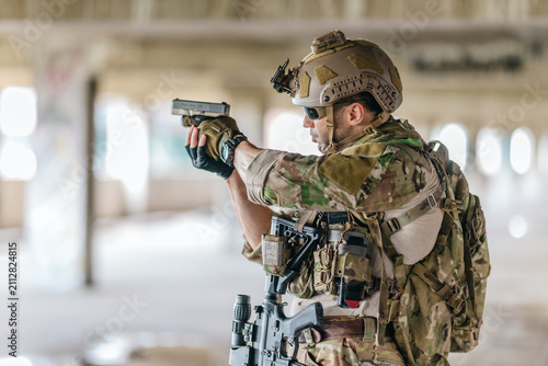 Foto Military tactical operator aims pistol during sidearm drill in abandoned concret