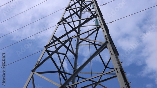 Fotografía Massive steel electricity pylon tower reaching into moody sky, symbol of power, energy, industry and modern civilization dominance