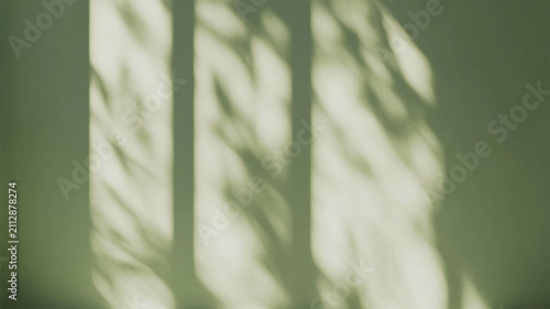 Abstract shadows of leaves on a light green wall create