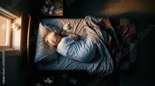 Person Lying In Bed Sick With Tissues Scattered Around