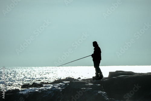 磯で釣りをする人物シルエット｜趣味や休日イメージに使える海景写真