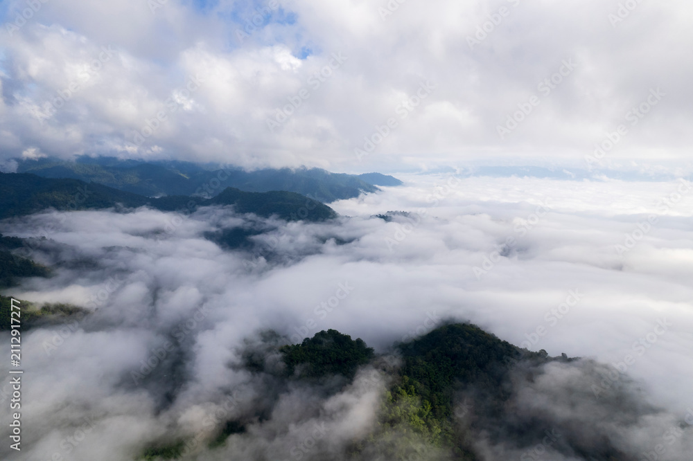 Fototapeta premium Landscape of Morning Mist with Mountain Layer. mountain ridge and clouds in rural jungle bush forest