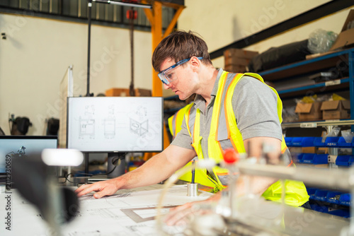 Engineer reviewing blueprints in workshop Industrial designer working on technical plans.
