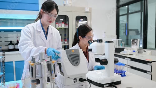 Team of scientists analyzing blue liquid samples in a modern lab, showcasing biotechnology, chemistry, and medical research innovation.
