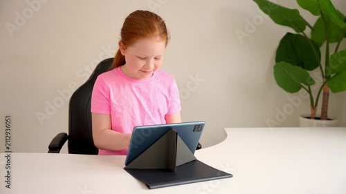 Child learns coding on tablet during afternoon at home