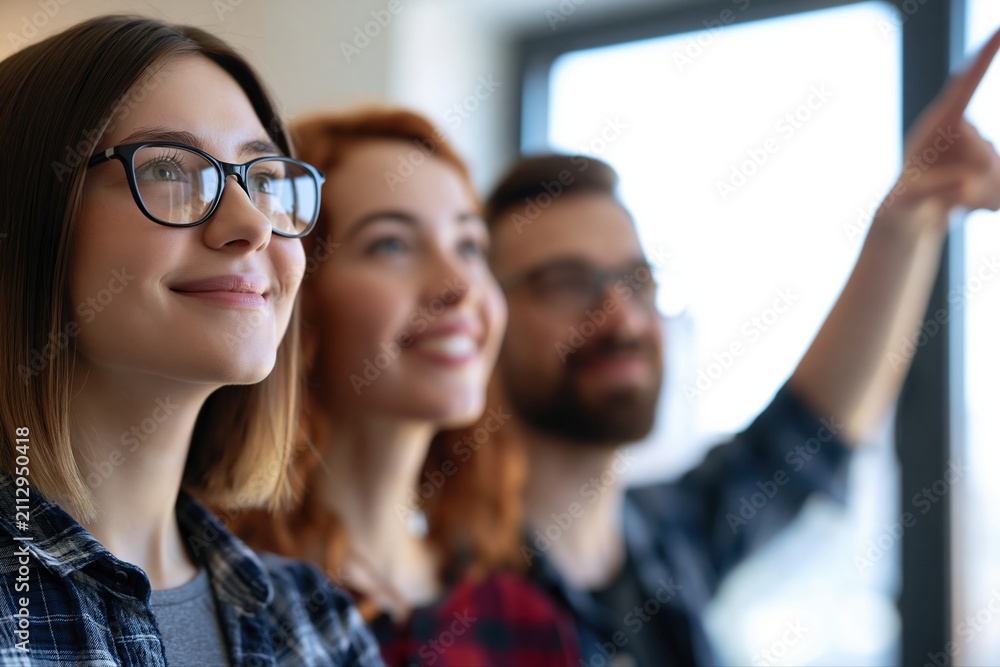 Fototapeta premium Diverse group of young professionals collaborating and pointing towards a bright future in an office setting