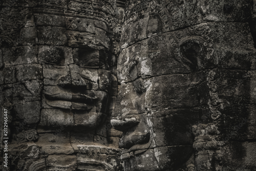 Fototapeta premium Close up of serene carved stone faces on the ancient towers of Bayon Temple at Angkor Thom in Siem Reap, Cambodia
