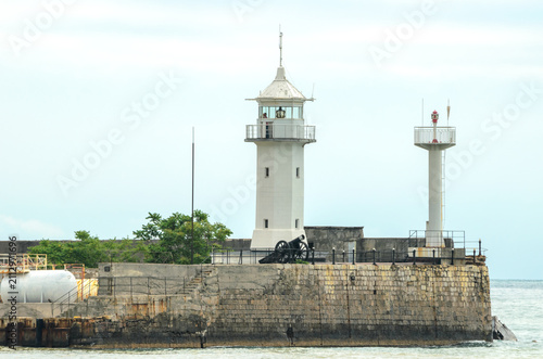 Fotografie Yalta Lighthouse White Tower with Cannon on Stone Pier by Black Sea Crimea Russi
